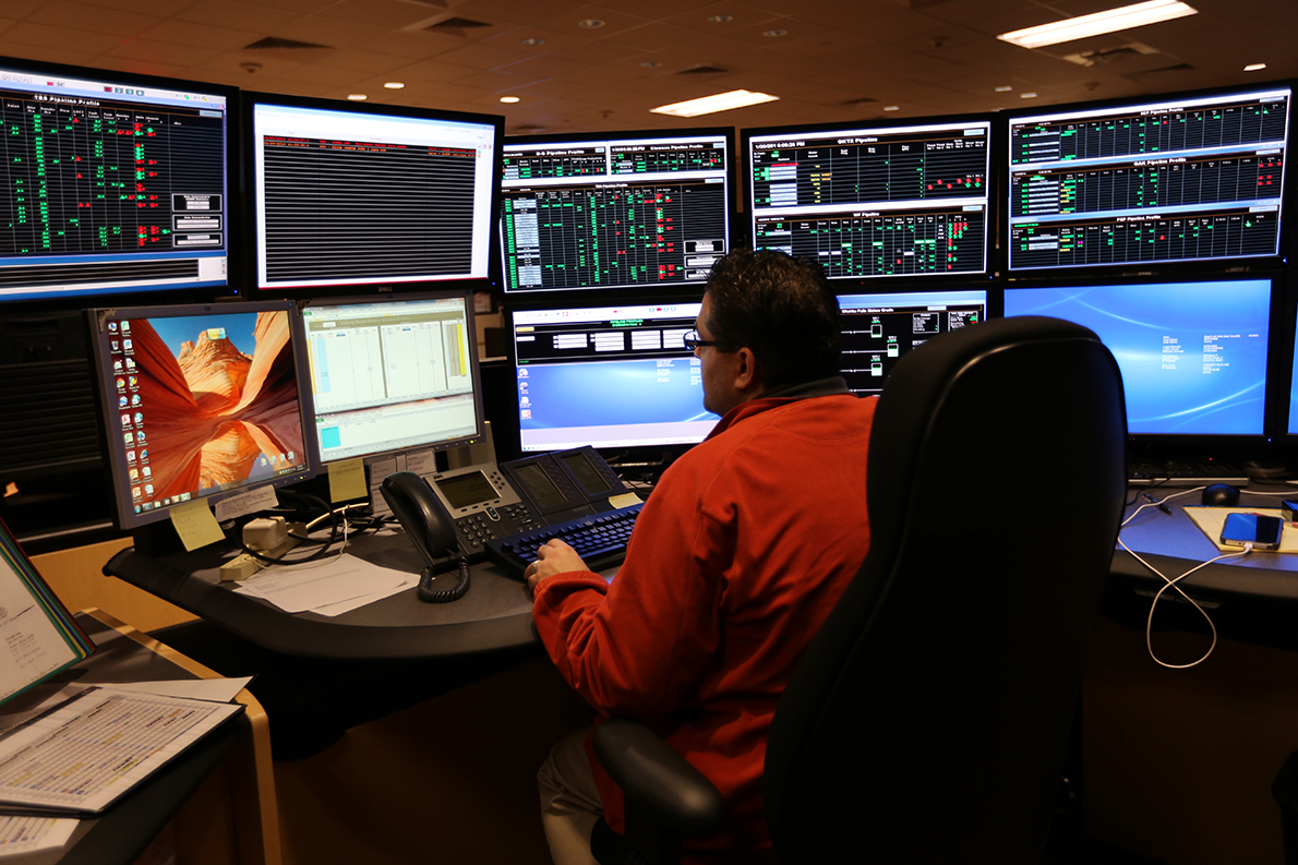 Image of NuStar employee working in the cybersecurity department with multiple computer monitors.