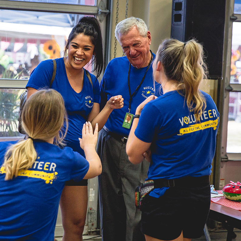 Image of chairman of the board, Bill Greehey, with volunteers at a NuStar volunteering event.