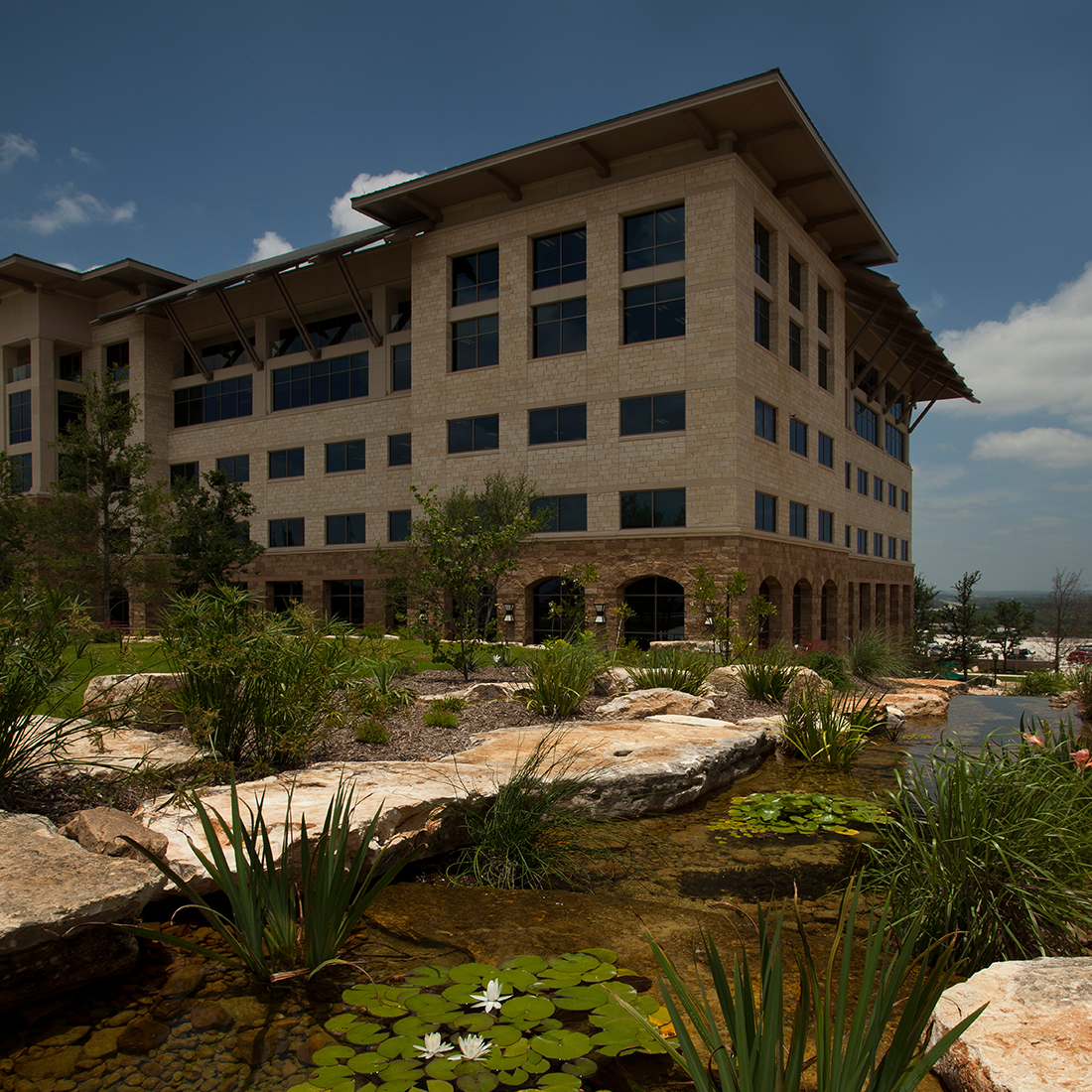 Image of NuStar’s headquarter building in the background with a pond and lily pads.