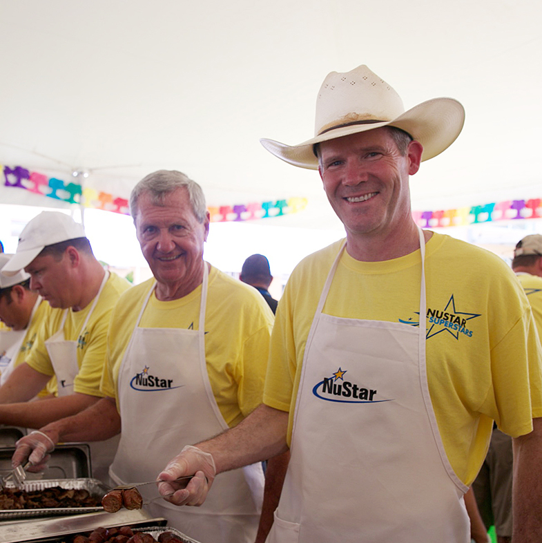 Image of NuStar President & CEO Brad Barron and Chairman of the Board Bill Greehey serving food at a volunteer event.